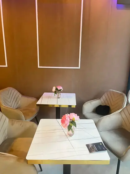 Gemütliche Sitzecke mit Samtsesseln und frischen Blumen